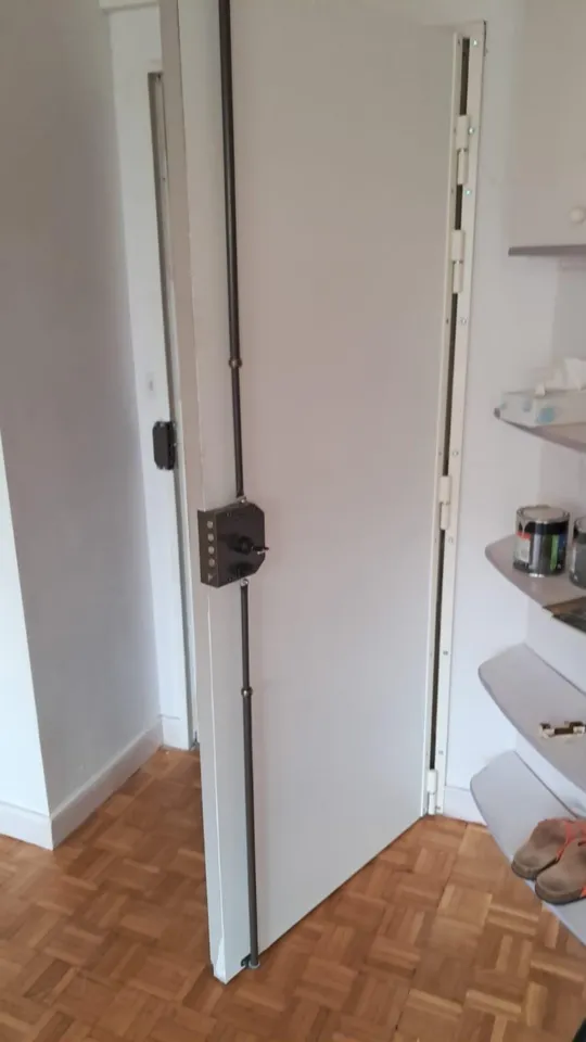 Serrure multipoints à tringles posée sur une porte d’appartement